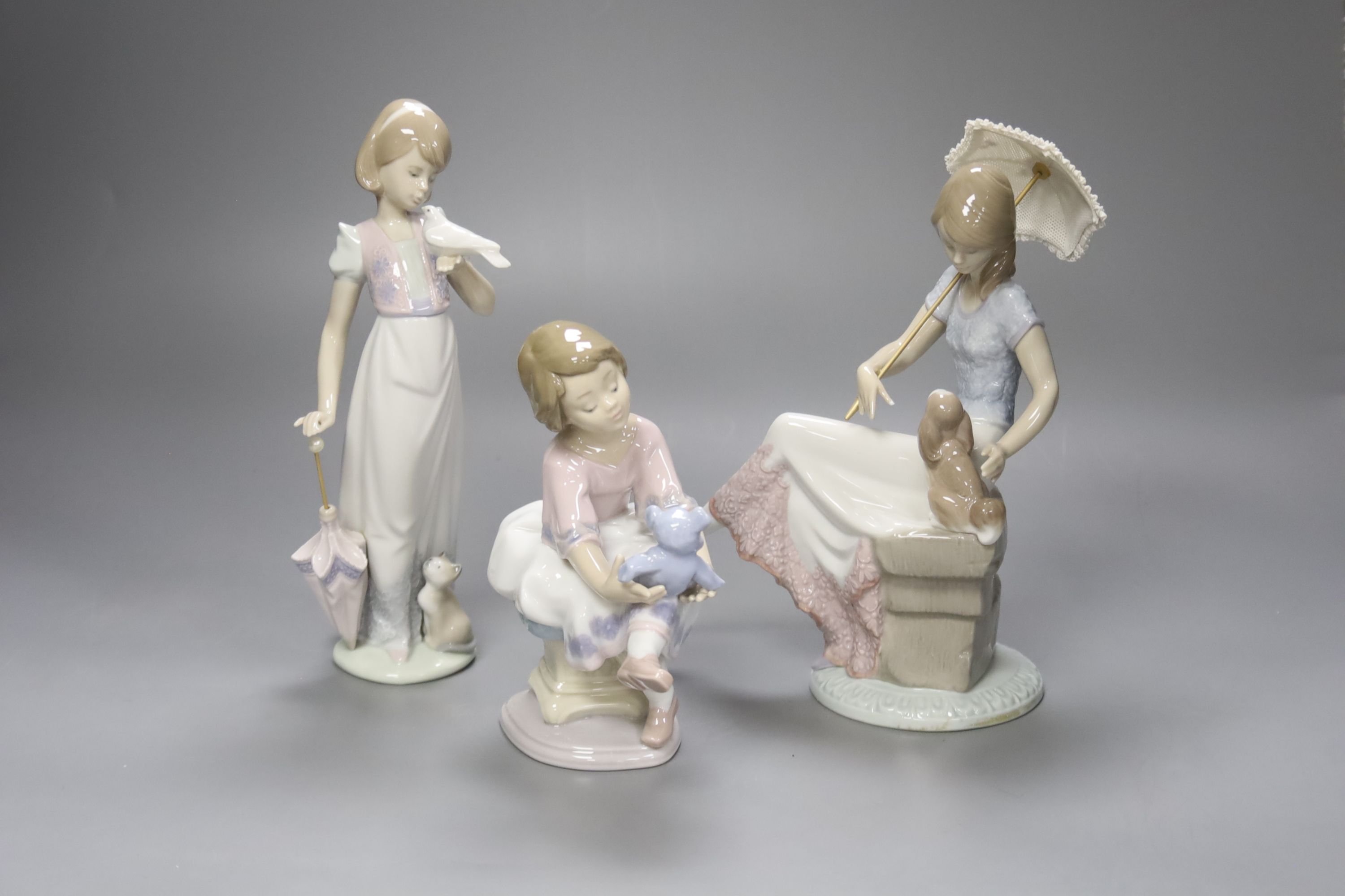 A Lladro figurine 'Best Friend', 'Summer Stroll' and 'Picture Perfect', tallest 22cm